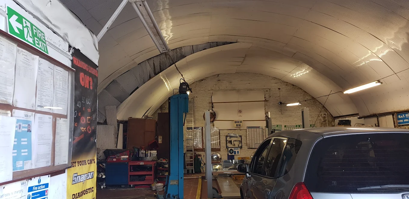 Inside the ADE Auto Repairs railway arch workshop with diagnostic banner and tools